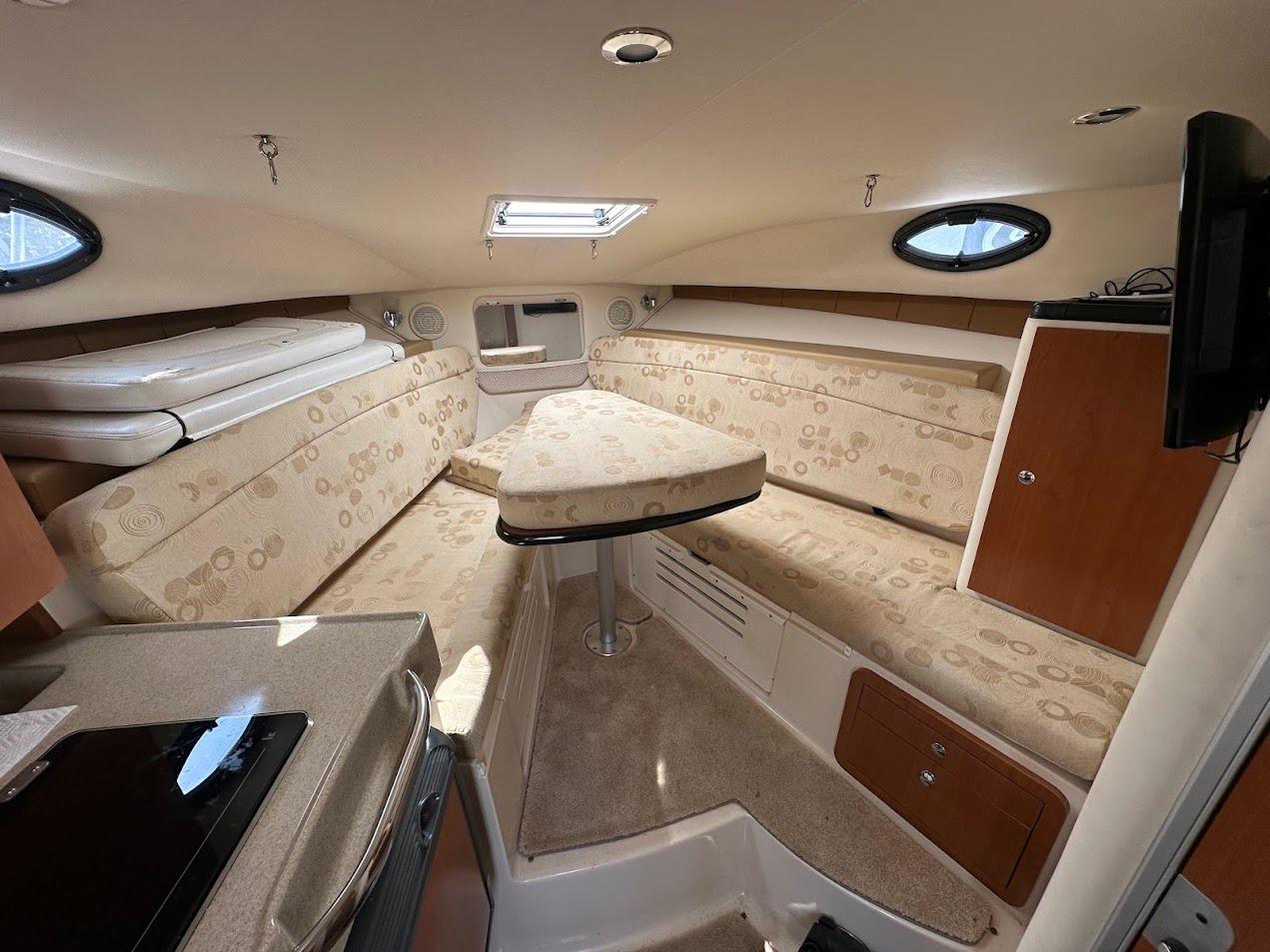 2006 Wellcraft 290 Coastal cabin interior with beige seating and compact amenities.