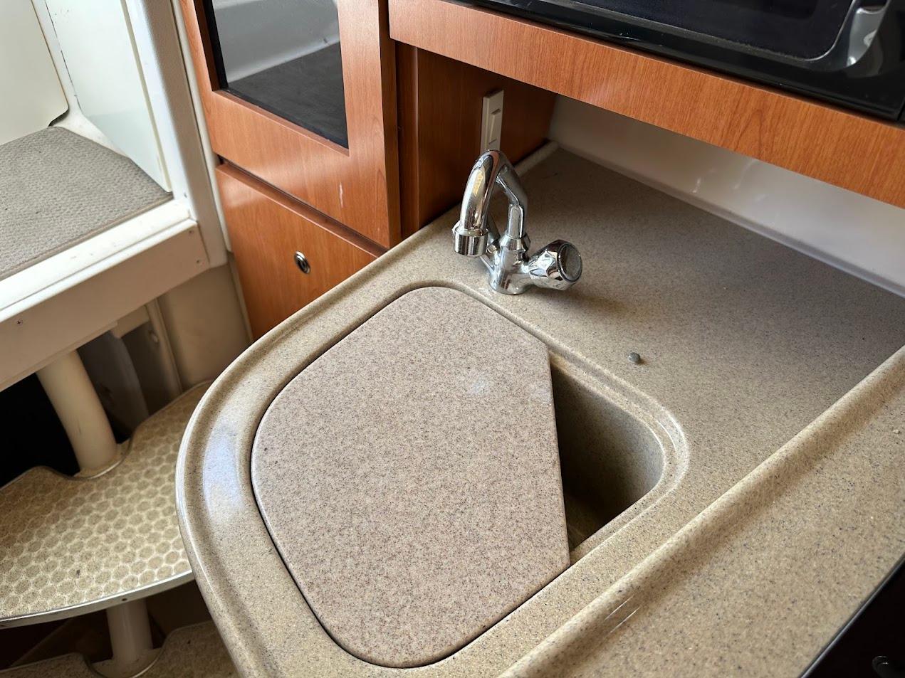 2006 Wellcraft 290 Coastal boat interior with sink and wooden cabinetry.