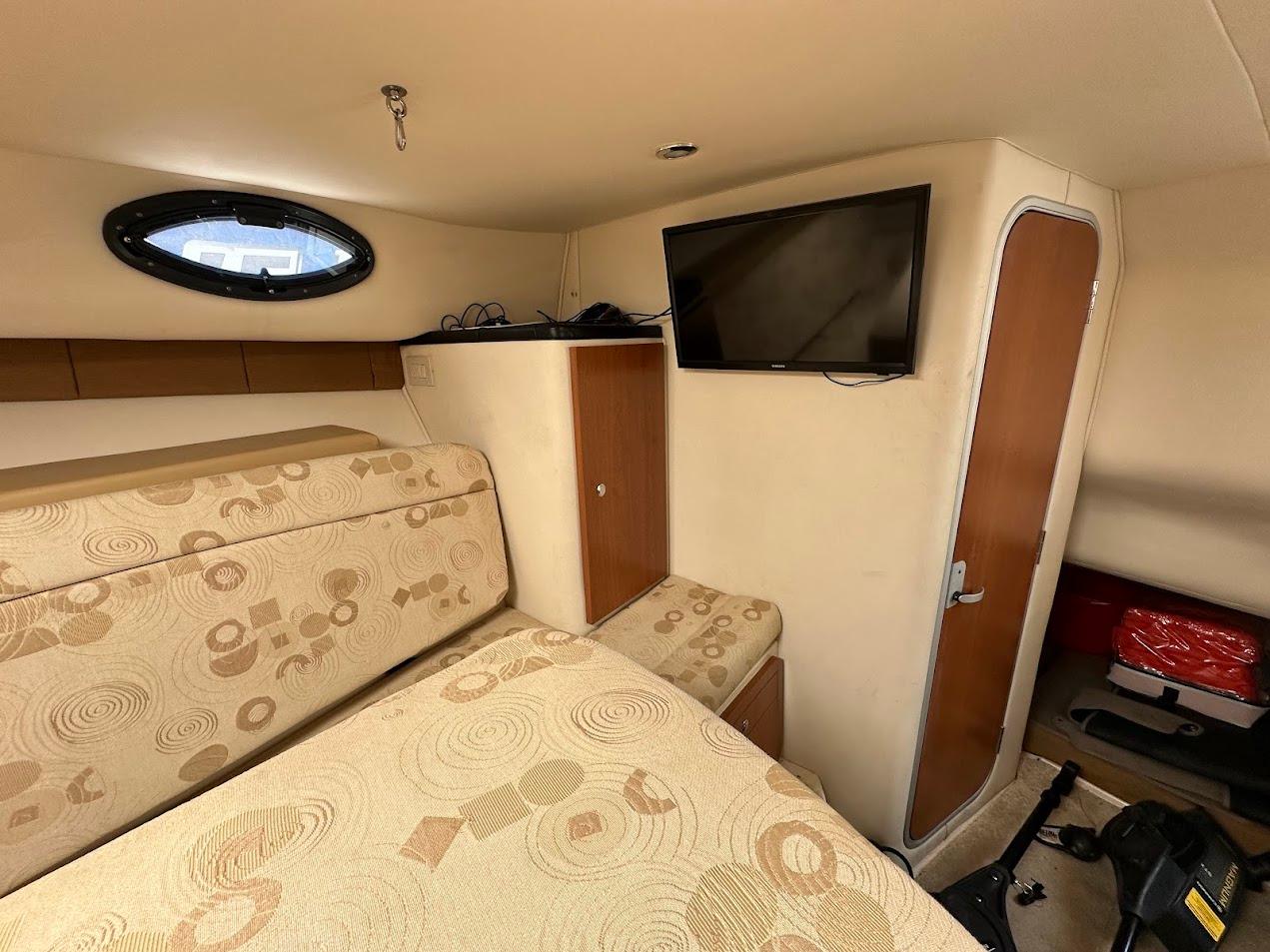 Interior of 2006 Wellcraft 290 Coastal boat with TV and patterned seating.