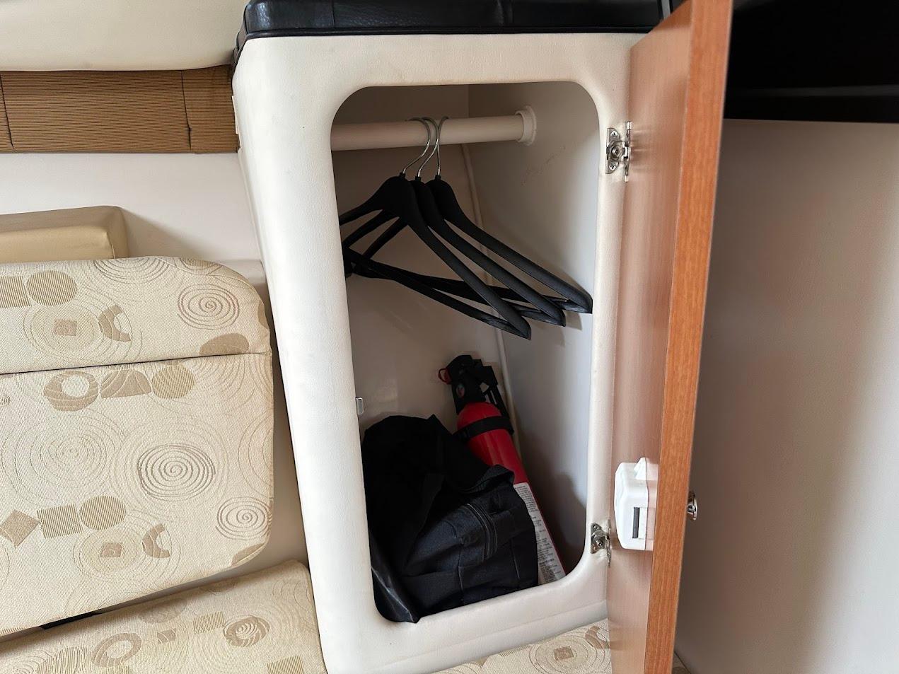 Small closet with hangers and bag inside a 2006 Wellcraft 290 Coastal boat.