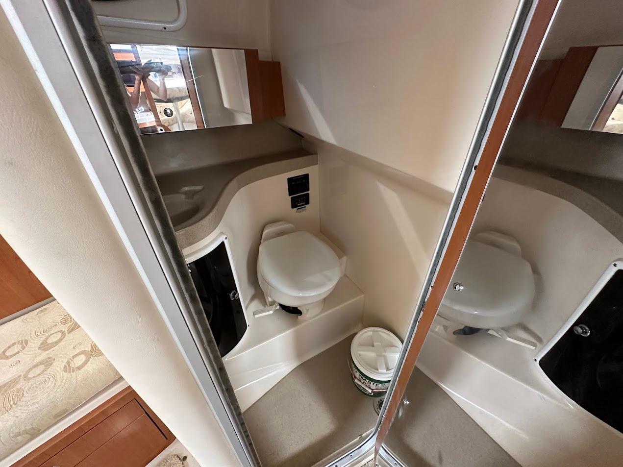 2006 Wellcraft 290 Coastal boat bathroom with toilet and mirror.