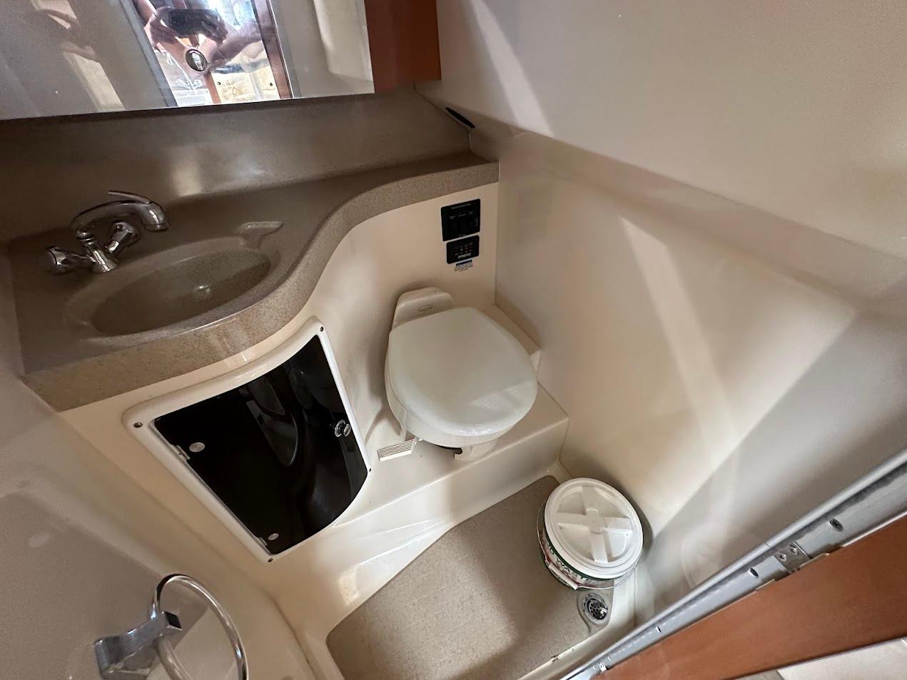 2006 Wellcraft 290 Coastal boat bathroom with sink, toilet, and storage.