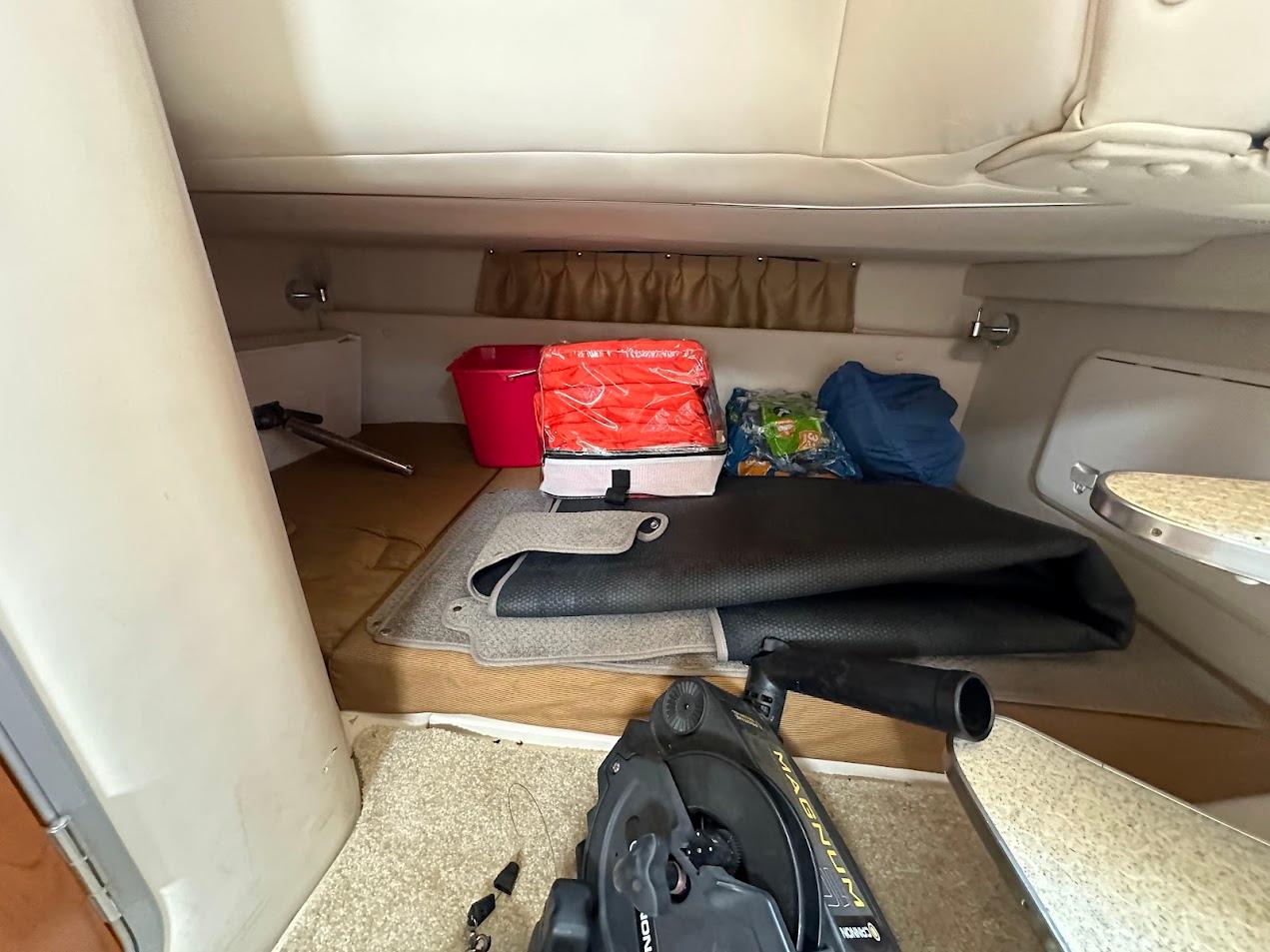 Interior cabin of a 2006 Wellcraft 290 Coastal boat with storage items.