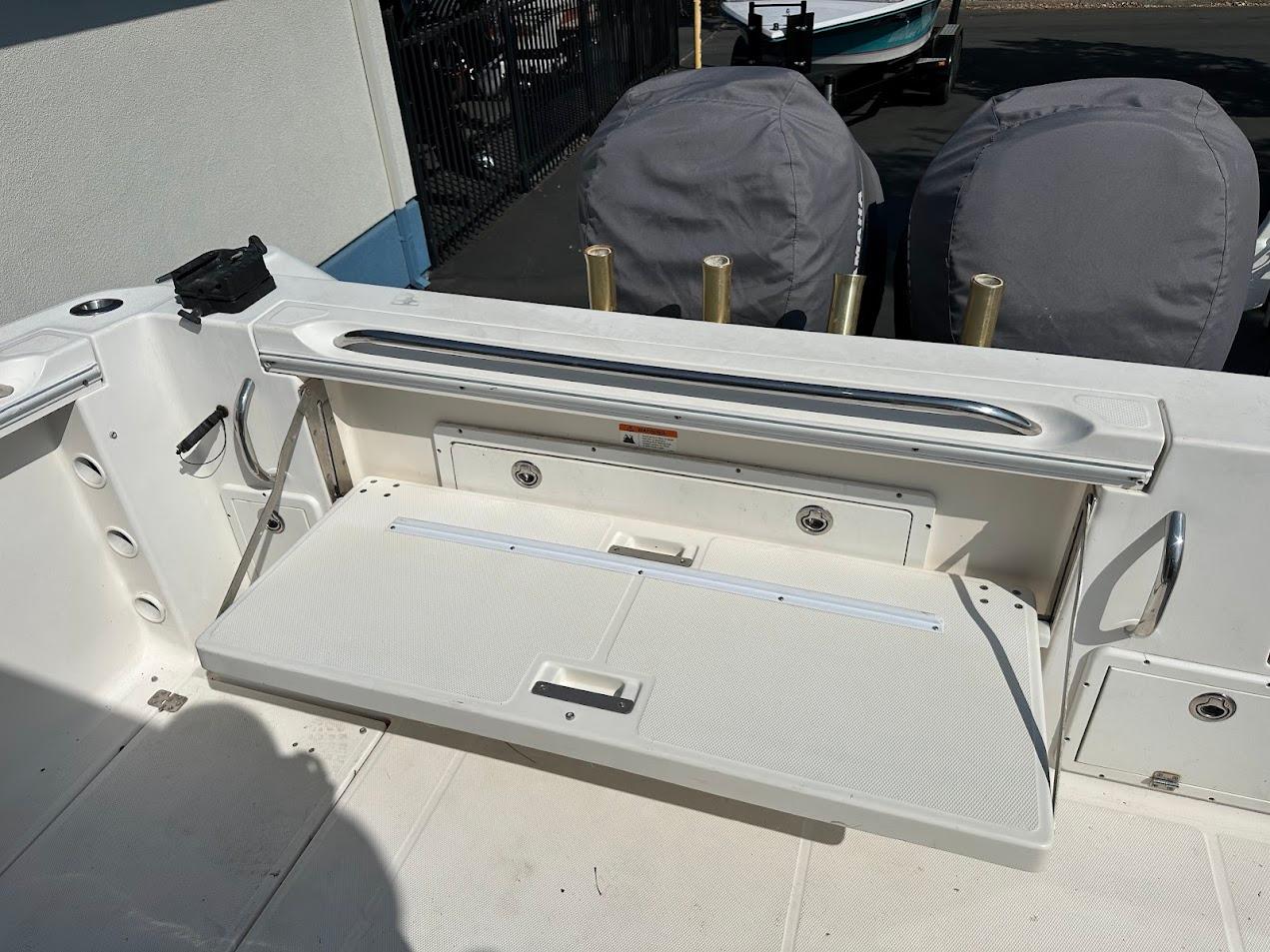 2006 Wellcraft 290 Coastal boat deck with foldable bench seat and rod holders.