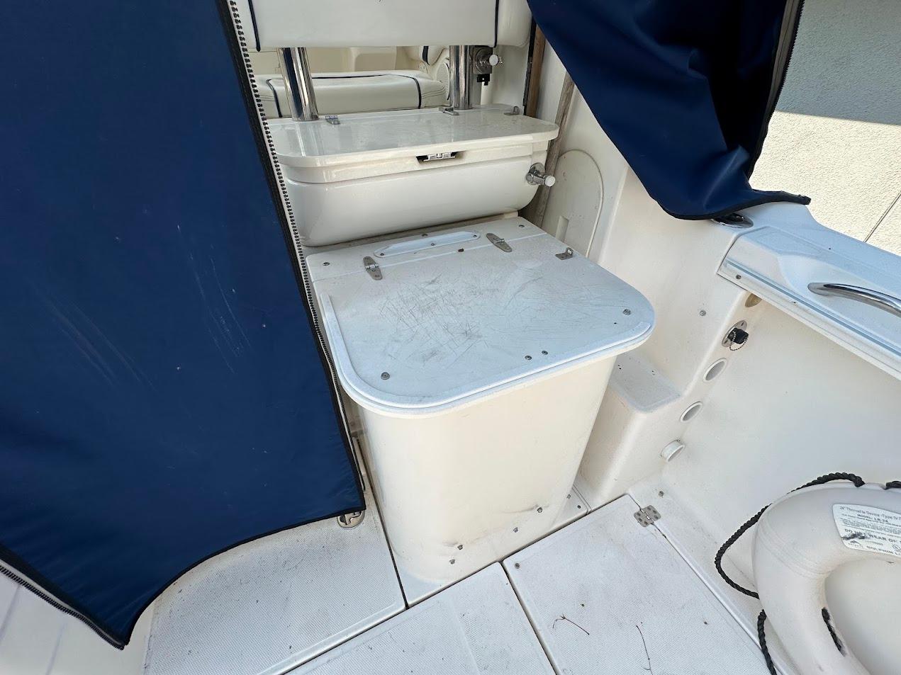 2006 Wellcraft 290 Coastal boat interior with storage compartment and blue curtain.