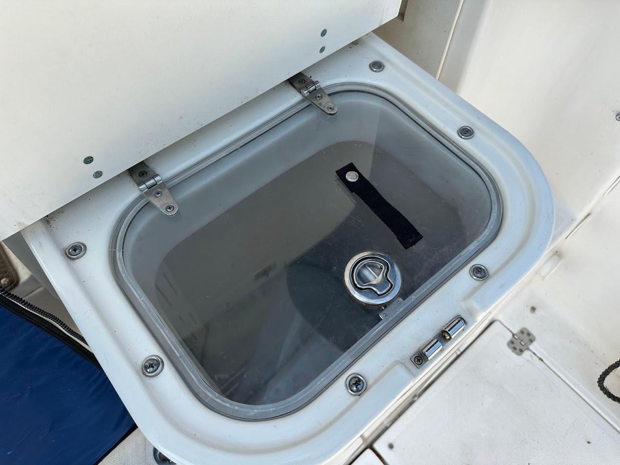 Livewell compartment on a 2006 Wellcraft 290 Coastal boat, featuring a secure latch.
