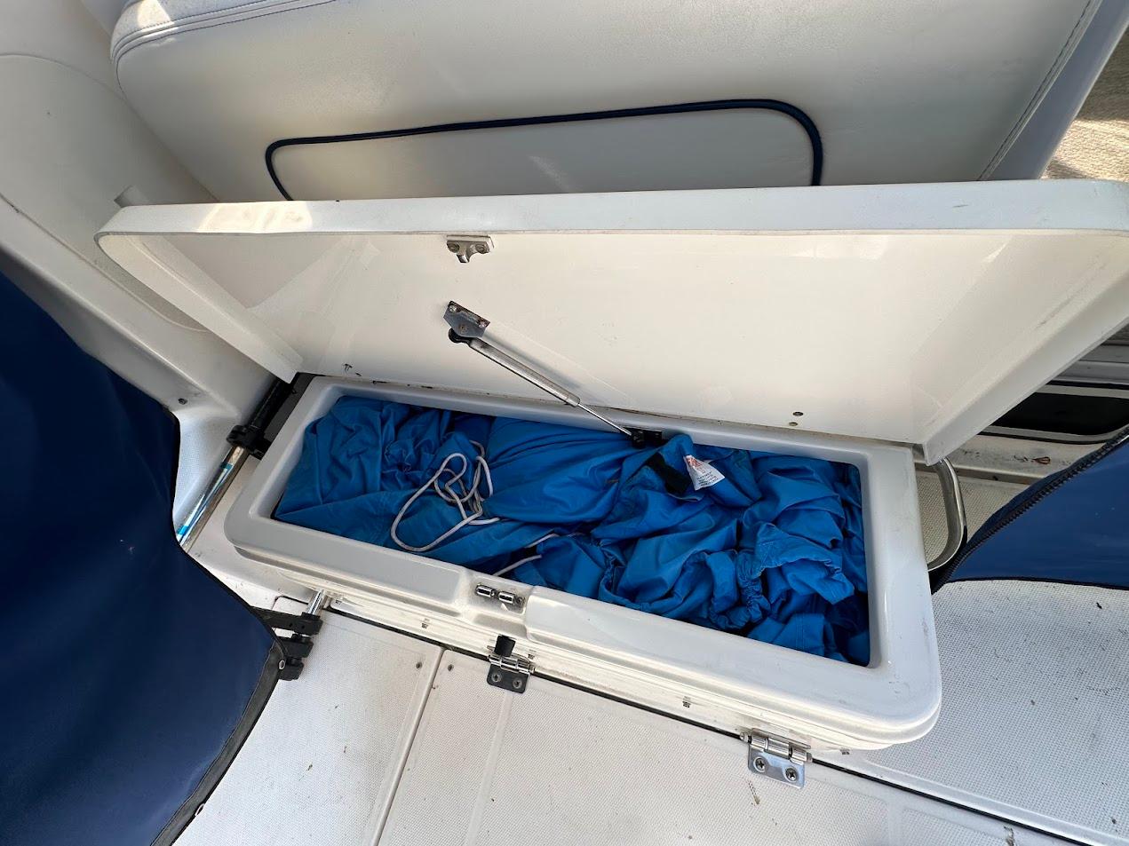 Open storage compartment on 2006 Wellcraft 290 Coastal boat with blue fabric inside.