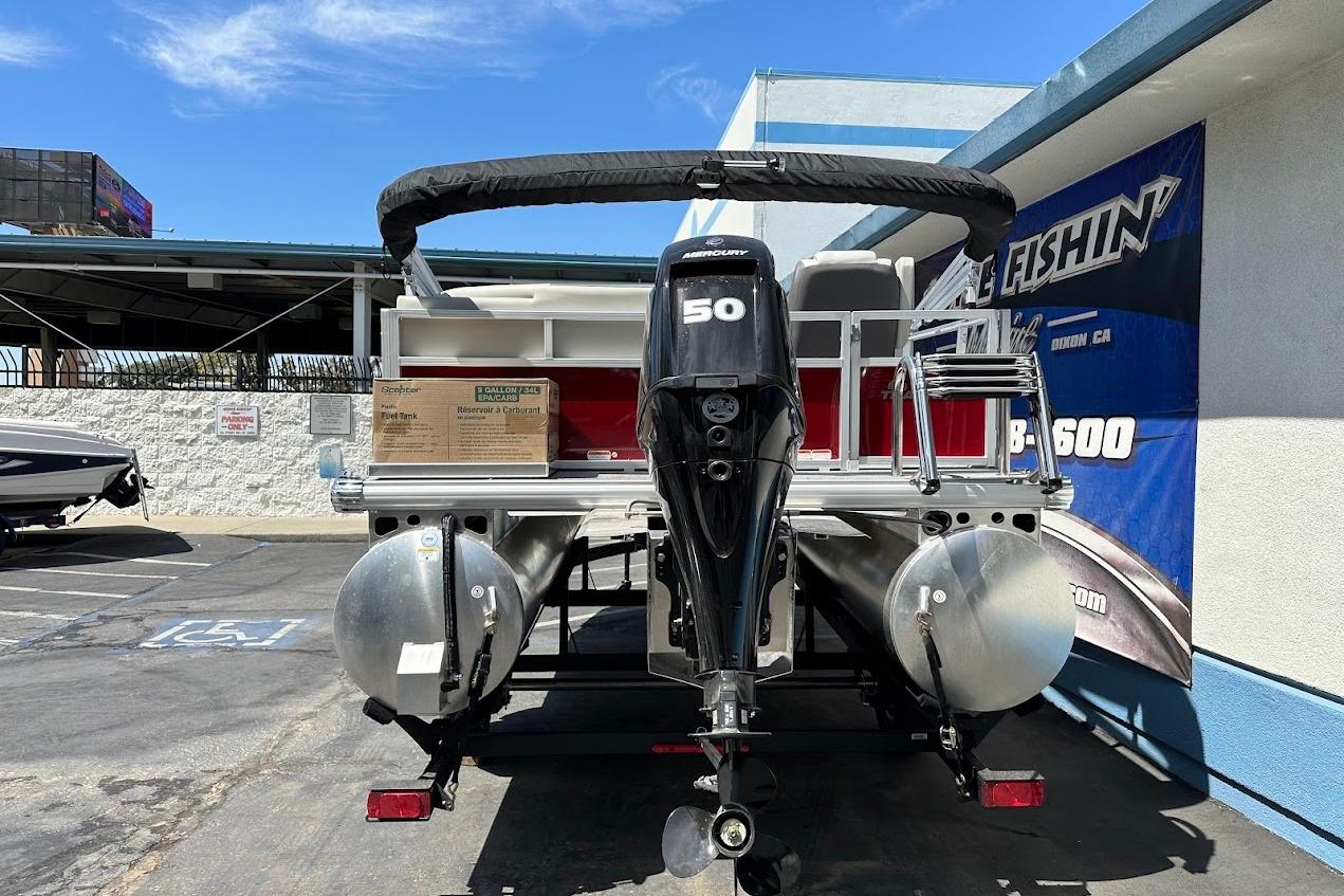 2026 Sun Tracker Bass Buggy 16 XL Select pontoon boat with Mercury 50 engine, parked outdoors.