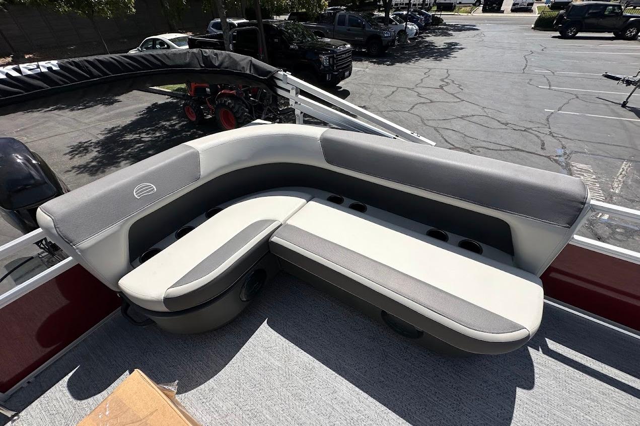2026 Sun Tracker Bass Buggy 16 XL Select boat seating, gray and white upholstery, outdoor setting.