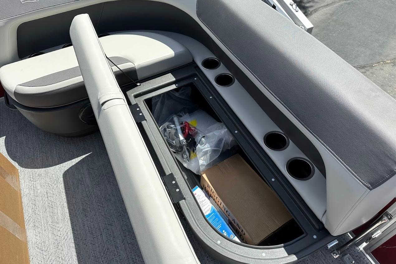 2026 Sun Tracker Bass Buggy 16 XL Select boat seat storage with cup holders and gear.