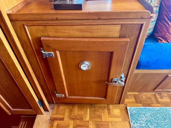 Wooden cabinet with a metal latch and gauge on a 1994 Grand Banks 42 Classic boat.