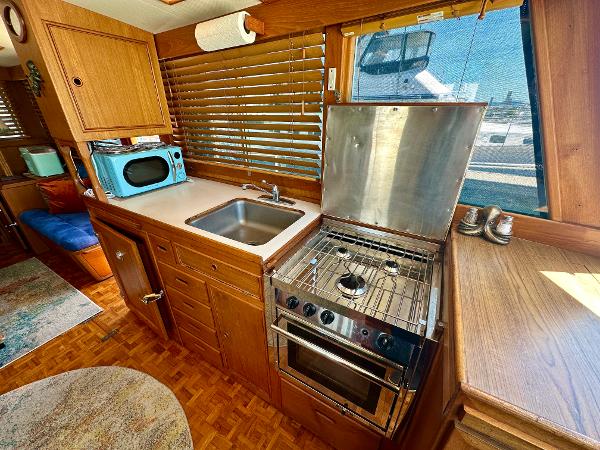 1994 Grand Banks 42 Classic yacht kitchen with stove, sink, and microwave.