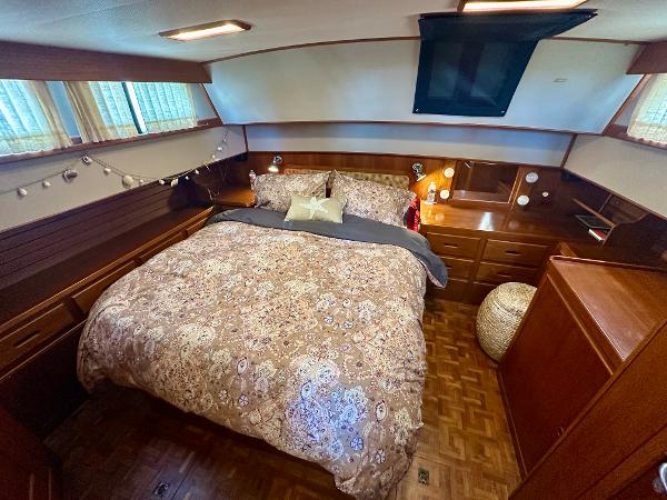 Cozy bedroom in 1994 Grand Banks 42 Classic yacht with elegant wood finish.