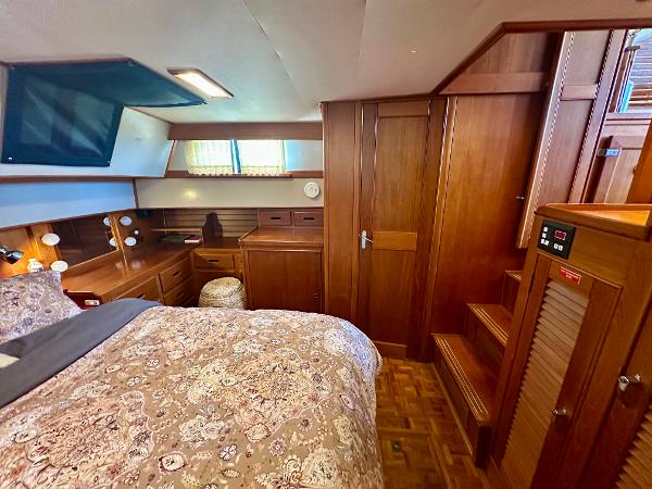 Luxurious 1994 Grand Banks 42 Classic yacht cabin with wood paneling and cozy bedding.