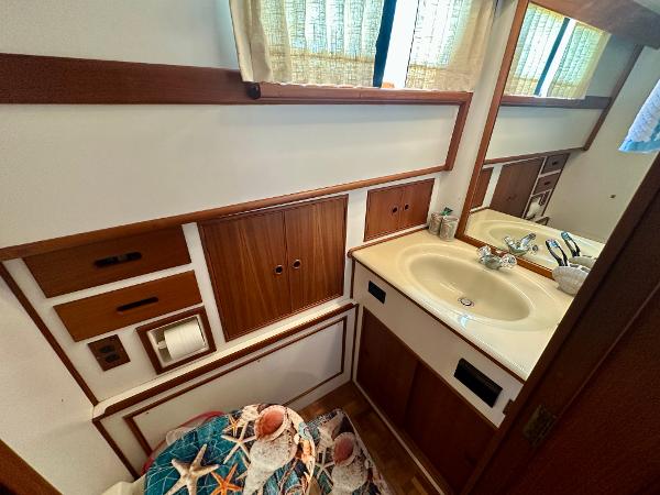 Bathroom interior of 1994 Grand Banks 42 Classic yacht, featuring wood accents and a sink.