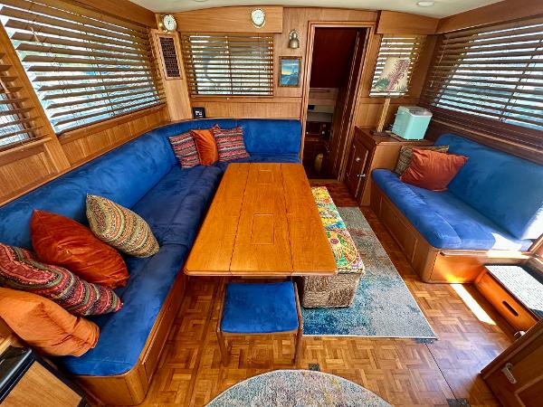 Interior of 1994 Grand Banks 42 Classic yacht with blue seating and wooden table.