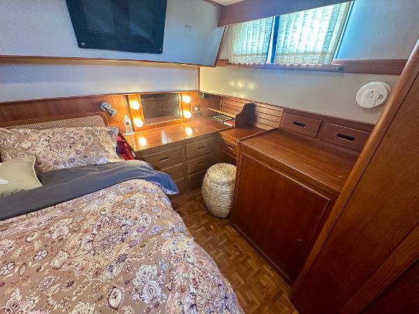 Cozy bedroom in 1994 Grand Banks 42 Classic yacht with wood furnishings and floral bedding.