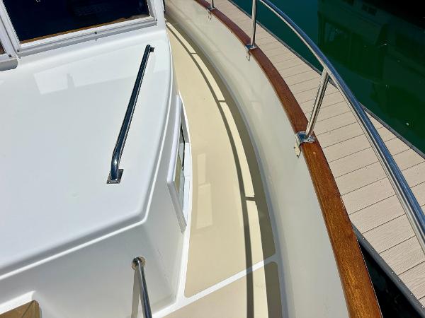 Deck view of a 1994 Grand Banks 42 Classic yacht with wooden railings.