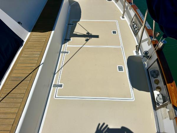 Deck of 1994 Grand Banks 42 Classic yacht with wooden trim and storage hatches.