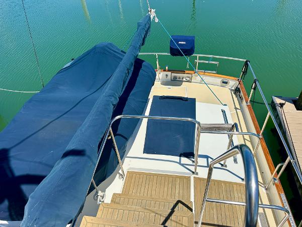 Grand Banks 42 Classic 1994 yacht deck with blue covers and wooden steps.