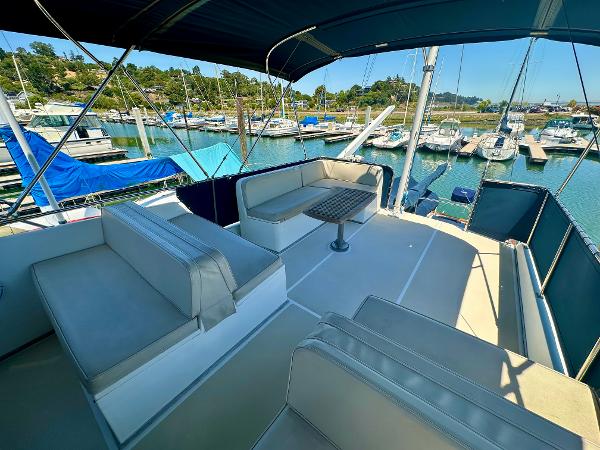 Flybridge of 1994 Grand Banks 42 Classic yacht with seating, table, and marina view.