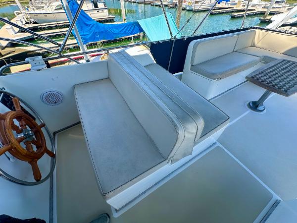1994 Grand Banks 42 Classic yacht interior with seating and wooden steering wheel.