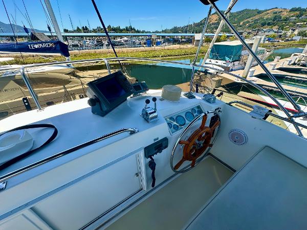 Helm of 1994 Grand Banks 42 Classic yacht with wooden steering wheel and navigation equipment.