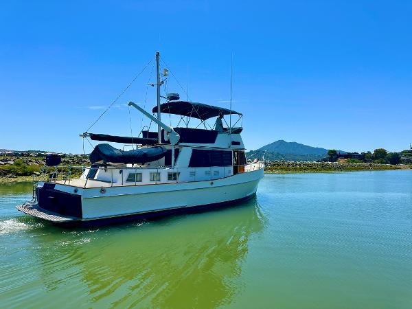 Grand Banks 42 Classic yacht from 1994 on calm water under clear blue sky.