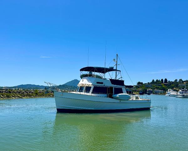 Grand Banks 42 Classic 1994 yacht on calm water under clear blue sky.