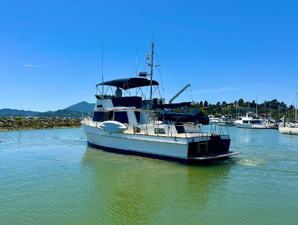 1994 Grand Banks 42 Classic yacht on calm water under clear blue sky.