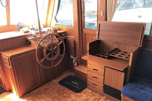 1994 Grand Banks 42 Classic yacht interior with wooden helm and storage compartments.