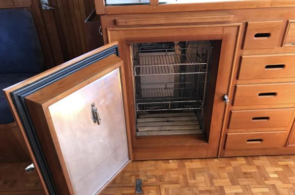 Open wooden cabinet with wire shelves on a 1994 Grand Banks 42 Classic boat.