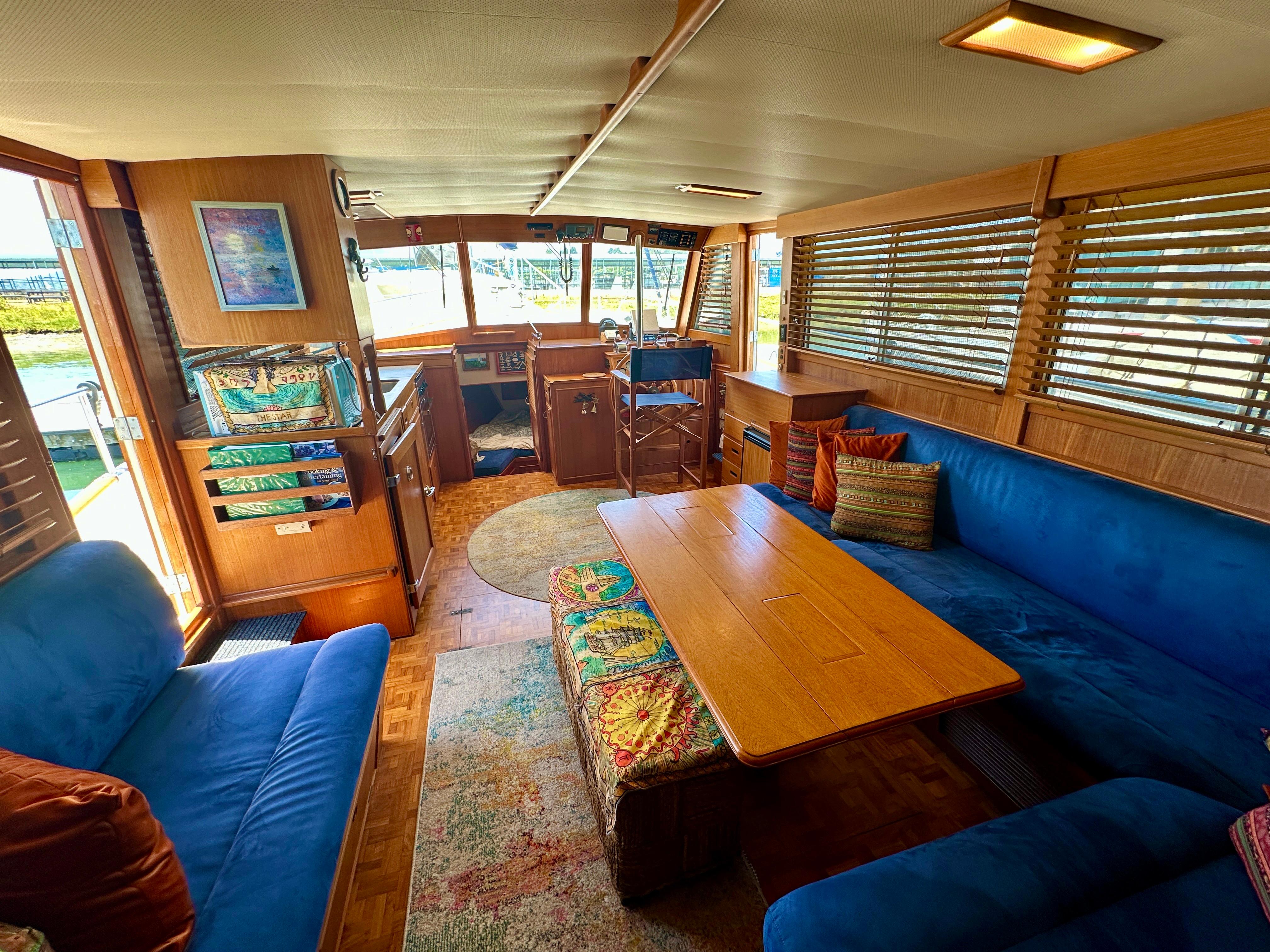 Interior of 1994 Grand Banks 42 Classic yacht with blue seating and wooden accents.