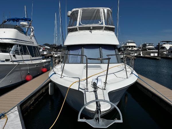1996 Carver 325 Aft Cabin yacht docked at marina under clear blue sky.
