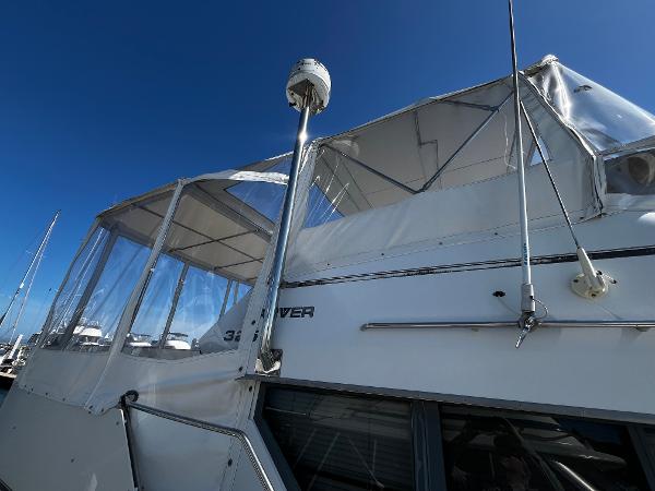 1996 Carver 325 Aft Cabin yacht with clear canopy under blue sky.