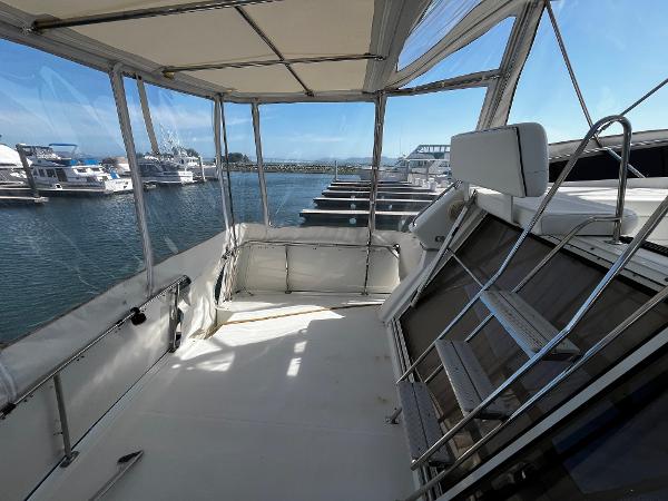 1996 Carver 325 Aft Cabin yacht interior with marina view, featuring spacious deck and seating.