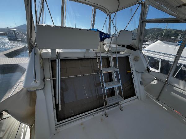 1996 Carver 325 Aft Cabin boat interior with ladder and seating, docked in marina.
