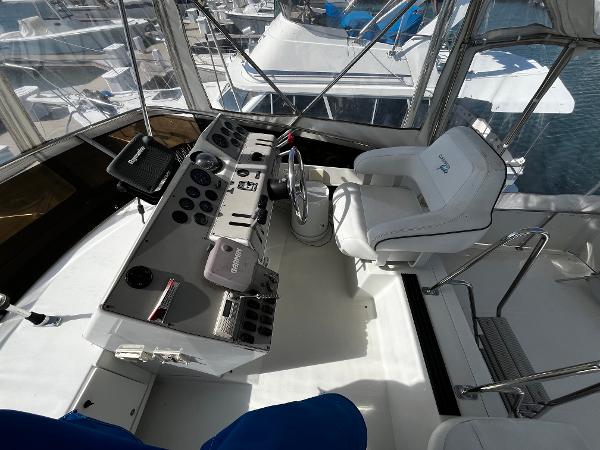 1996 Carver 325 Aft Cabin helm with steering wheel and control panel, docked at marina.