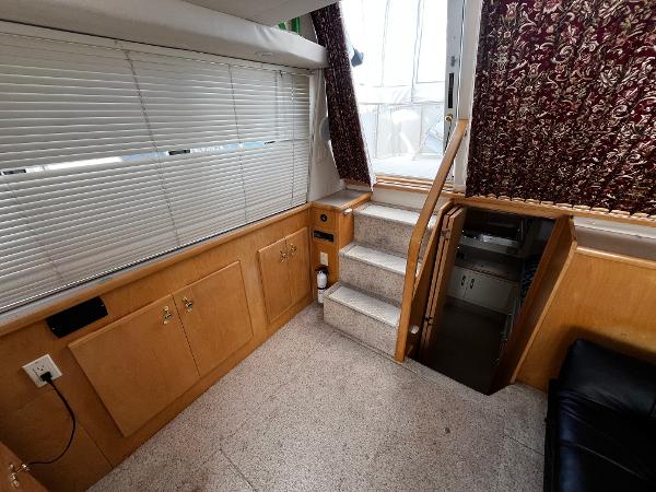 Interior of 1996 Carver 325 Aft Cabin with stairs, cabinets, and window blinds.