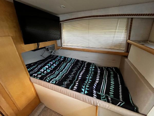 1996 Carver 325 Aft Cabin interior with bed, TV, and window blinds.