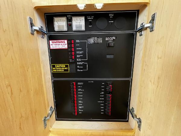 Electrical panel inside 1996 Carver 325 Aft Cabin boat, featuring switches and warning labels.