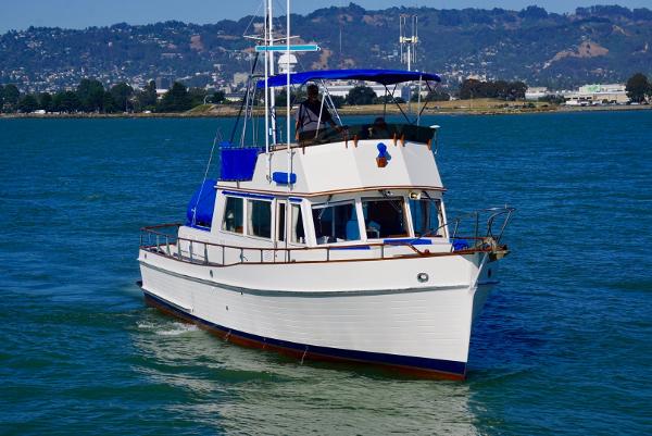 1982 Grand Banks Classic boat cruising on a scenic waterway.