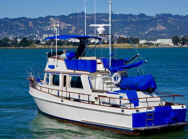 1982 Grand Banks Classic boat on water with blue accents and scenic background.