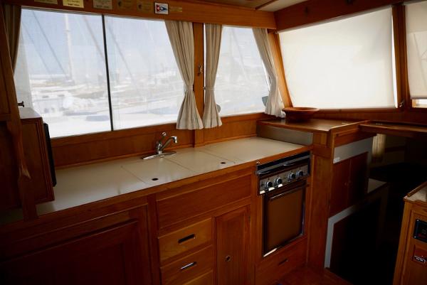 Interior of 1982 Grand Banks Classic yacht with wooden cabinetry and kitchen area.