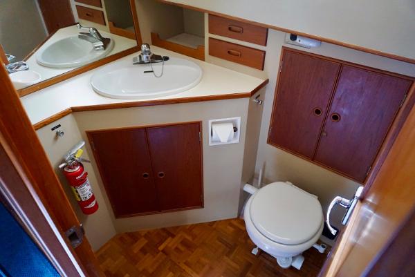 1982 Grand Banks Classic yacht bathroom with sink, toilet, and wooden cabinetry.