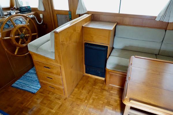1982 Grand Banks Classic interior with wooden helm, seating, and storage.