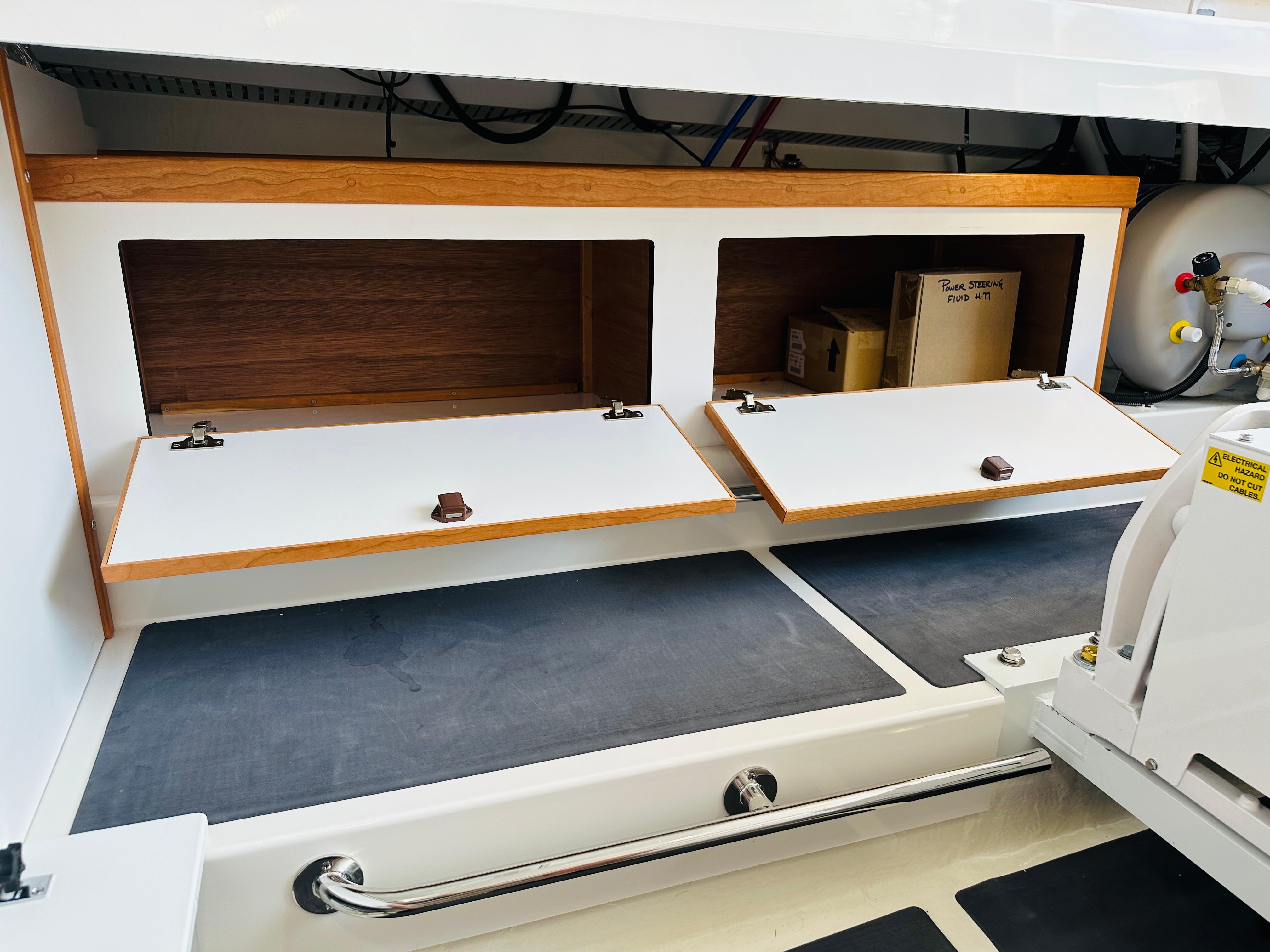 2023 Back Cove 34O storage compartments with open wooden doors and visible interior.
