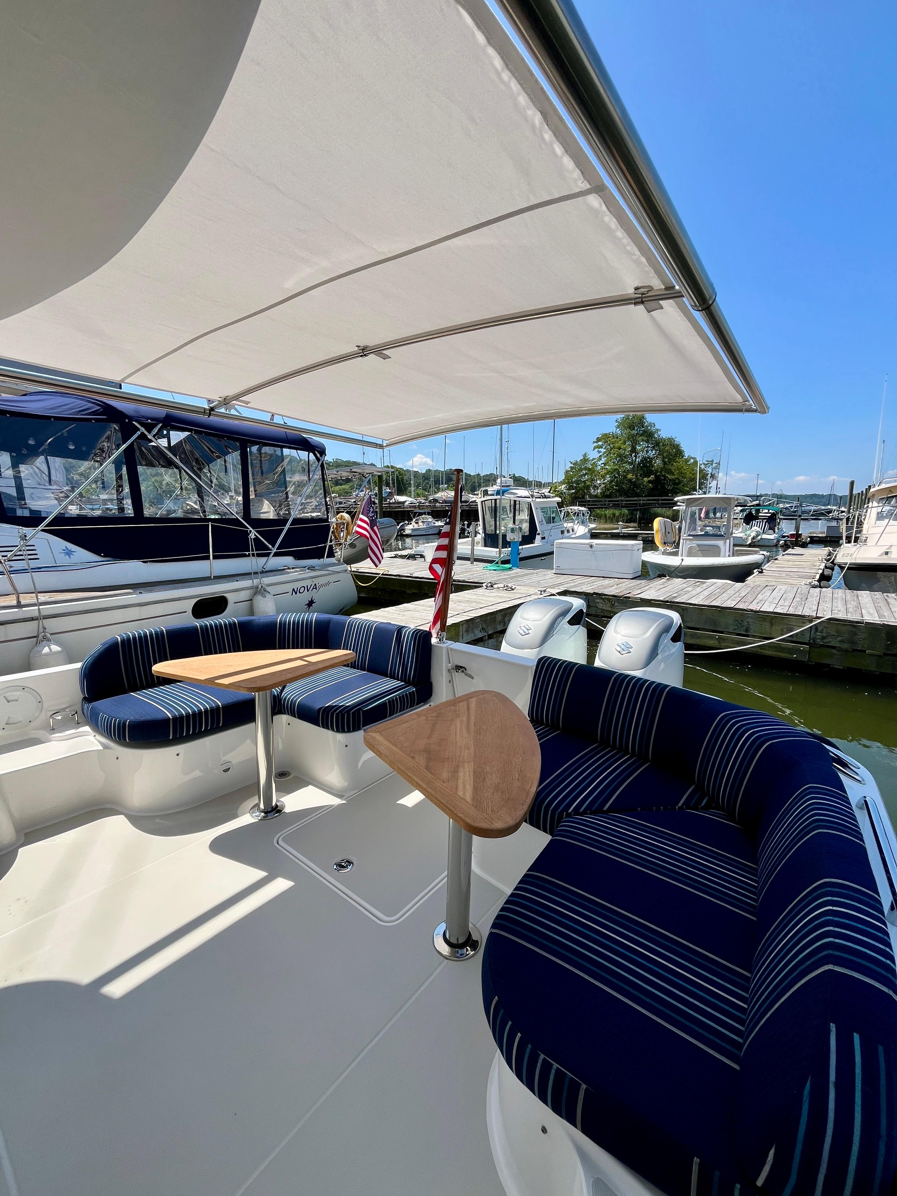 2023 Back Cove 34O yacht with shaded seating area at marina.