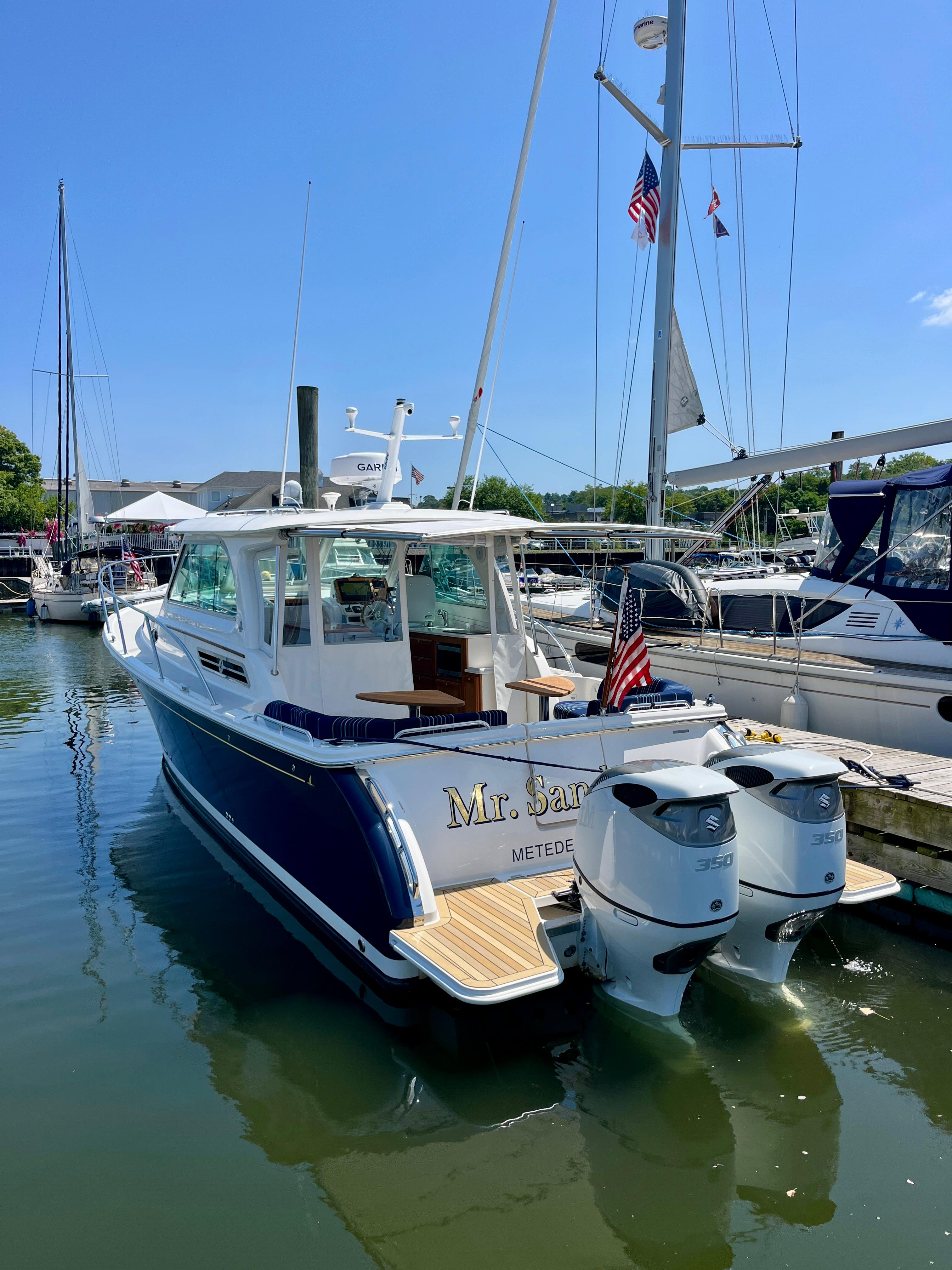 2023 Back Cove 34O boat docked, featuring dual outboard engines and American flag.