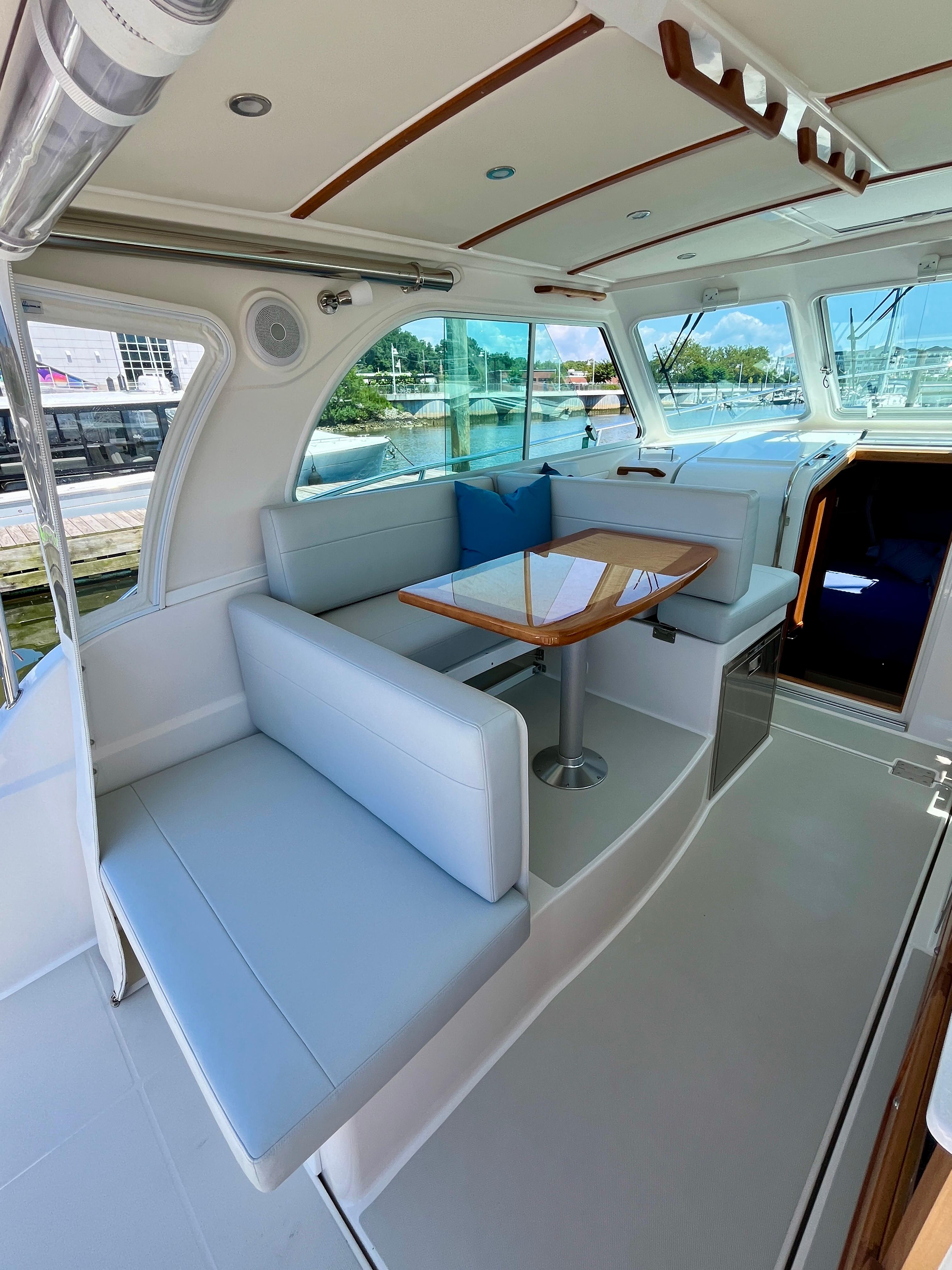 2023 Back Cove 34O yacht interior with elegant seating and wooden table.